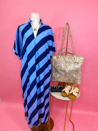 Relaxed midi dress with a notched neckline, soft collar detail, short sleeves, and bold diagonal navy and blue stripe pattern