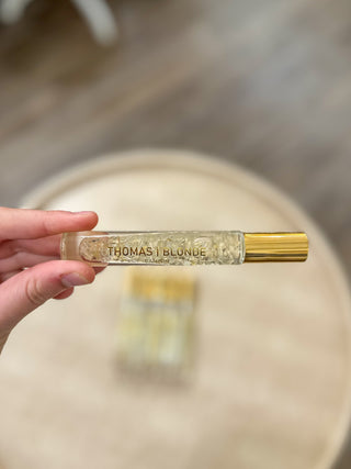 a Thomas Blonde rollerball perfume bottle with a gold cap