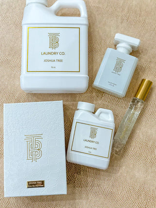 Thomas Blonde scent Joshua Tree, including a large white jug, a smaller bottle, a roll-on perfume bottle with a gold cap, and a textured white box.