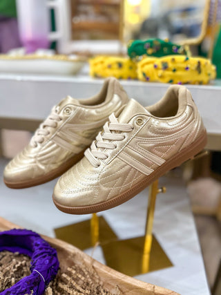 Metallic champagne-gold casual sneakers with quilted stitching and gum soles